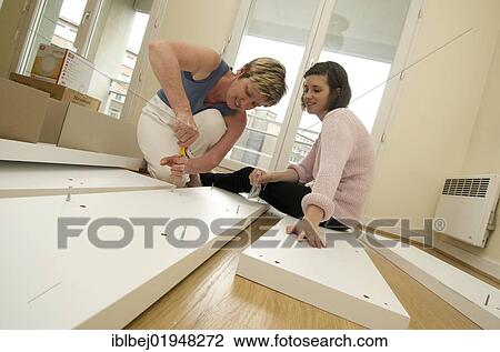 Two women assembling a shelf View Large Photo Image Stock Image - Two women assembling a shelf. Fotosearch