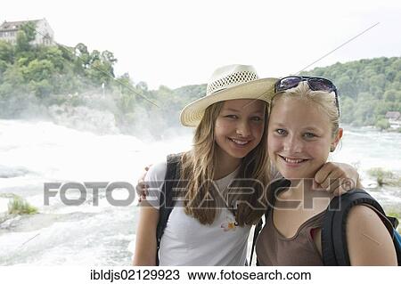 Stock Image - Two young women tourists, Rhine Falls, Schaffhausen, Switzerland, Europe. Fotosearch
