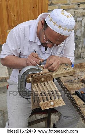 Uzbek man carving a Quran, Qur´an holder, historic town of Bukhara, Buchara, Silk Road, Unesco World Heritage Site, Central Asia View Large Photo Image Stock Photo - Uzbek man carving a Quran, Qur´an holder, historic town of Bukhara, Buchara, Silk Road, Unesco World Heritage Site, Central Asia. Fotosearch