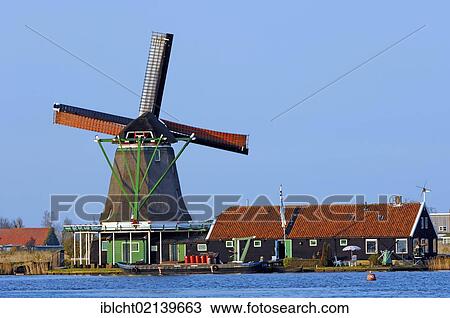 Stock Image - Windmill and house in Zaanse Schans open-air museum, Zaanstad, North Holland, Holland, Netherlands, Europe. Fotosearch