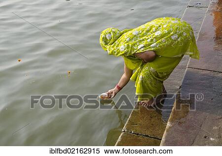 Woman giving offerings to the holy river Ganges as part of her pilgrimage to Varanasi, Uttar Pradesh, India, Asia View Large Photo Image Stock Photography - Woman giving offerings to the holy river Ganges as part of her pilgrimage to Varanasi, Uttar Pradesh, India, Asia. Fotosearch