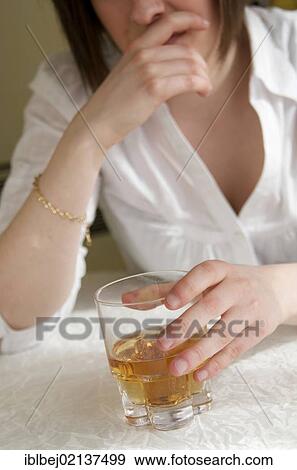 Woman holding a glass of hard liquor, female alcoholism View Large Photo Image Stock Photo - Woman holding a glass of hard liquor, female alcoholism. Fotosearch