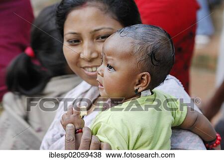 Woman holding a toddler, Taumadhi square, Bhaktapur, Kathmandu Valley, Nepal, Asia View Large Photo Image Stock Photo - Woman holding a toddler, Taumadhi square, Bhaktapur, Kathmandu Valley, Nepal, Asia. Fotosearch
