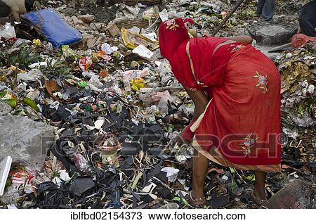 Stock Image - Woman of a low caste sorting out the recyclable parts at a rubbish dump, Kolkata, West Bengal, India, Asia. Fotosearch