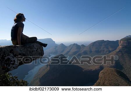 Woman sitting on a rock with a view across Blyde River Canyon, Mpumalanga, South Africa, Africa View Large Photo Image Stock Photo - Woman sitting on a rock with a view across Blyde River Canyon, Mpumalanga, South Africa, Africa. Fotosearch