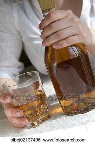 Woman's hands holding a bottle and a glass of hard liquor, female alcoholism View Large Photo Image Stock Photograph - Woman's hands holding a bottle and a glass of hard liquor, female alcoholism. Fotosearch