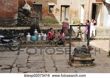 Stock Photograph - Women fetching water from a well, Bhaktapur, Kathmandu Valley, Nepal, Asia. Fotosearch