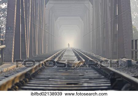 Stock Photo - Worker walking along the railway-bridge crossing the river Yamuna, Agra, Uttar Pradesh, India, Asia. Fotosearch