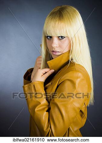 Stock Image - Young blond woman wearing a leather jacket. Fotosearch