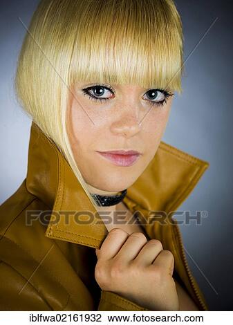 Stock Image - Young blond woman wearing a leather jacket. Fotosearch