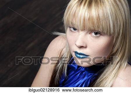 Stock Photograph - Young blond woman wearing blue lipstick, portrait. Fotosearch