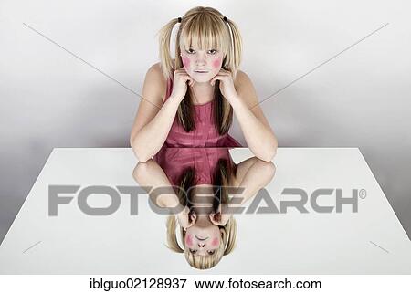 Young blond woman with red painted cheeks, smiling, with a mirrored image View Large Photo Image Stock Photo - Young blond woman with red painted cheeks, smiling, with a mirrored image. Fotosearch