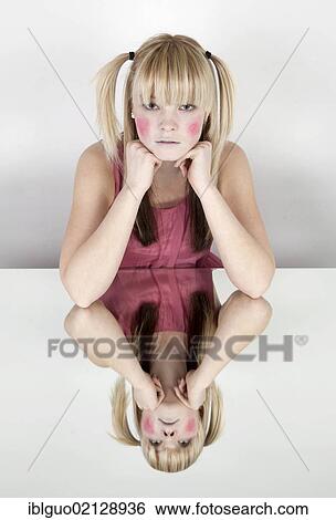 Young blond woman with red painted cheeks, smiling, with a mirrored image View Large Photo Image Stock Photograph - Young blond woman with red painted cheeks, smiling, with a mirrored image. Fotosearch