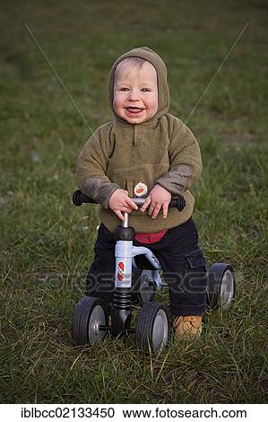 Young boy, 1, seated on a four-wheel Puky push bike, learning to walk, looking happy, Germany, Europe View Large Photo Image Stock Image - Young boy, 1, seated on a four-wheel Puky push bike, learning to walk, looking happy, Germany, Europe. Fotosearch
