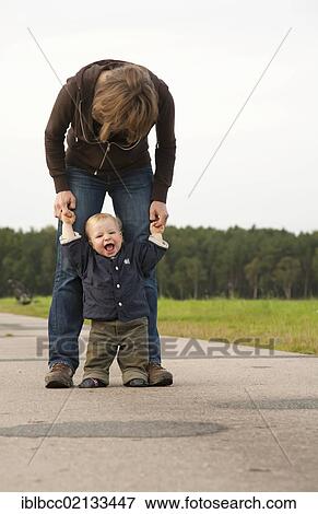 Stock Photo - Young boy, 1, with his mother, learning to walk on a dirt road, rejoicing with joy and satisfaction, Germany, Europe. Fotosearch