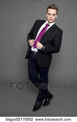 Young man in a suit and a tie, business attire View Large Photo Image Stock Image - Young man in a suit and a tie, business attire. Fotosearch