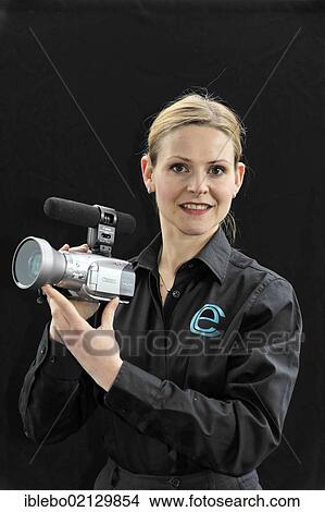Picture - Young professional videographer shooting with a film camera. Fotosearch