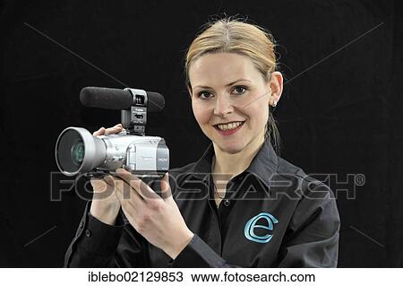 Stock Image - Young professional videographer shooting with a film camera. Fotosearch