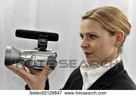 Stock Photo - Young professional videographer shooting with a film camera. Fotosearch