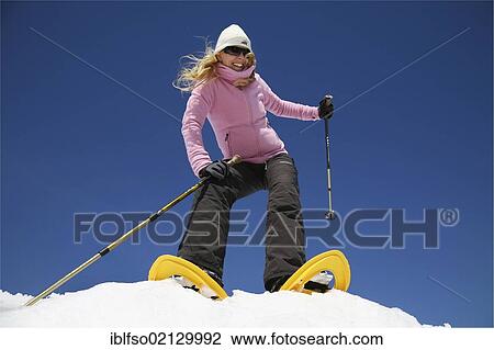 Young woman, about 25, using snowshoes with stocks in her hands, in the snow in front of clear blue sky, Thuringian Forest, Thuringia, Germany, Europe View Large Photo Image Stock Image - Young woman, about 25, using snowshoes with stocks in her hands, in the snow in front of clear blue sky, Thuringian Forest, Thuringia, Germany, Europe. Fotosearch