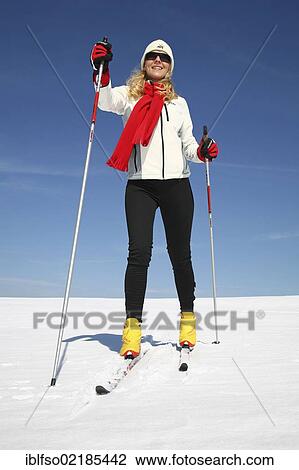 Stock Image - Young woman, about 25 years, against a blue sky, cross-country skiing, near Masserberg, Thuringian Forest mountains, Thuringia, Germany, Europe. Fotosearch
