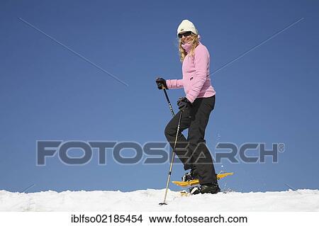 Young woman, about 25 years, snow shoe walking with sticks, against a blue sky, Thuringian Forest mountains, Thuringia, Germany, Europe View Large Photo Image Picture - Young woman, about 25 years, snow shoe walking with sticks, against a blue sky, Thuringian Forest mountains, Thuringia, Germany, Europe. Fotosearch