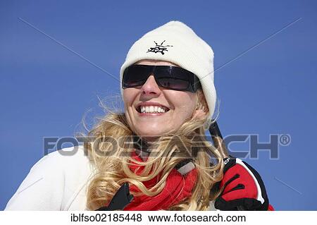 Young woman, about 25 years, wearing a bright cap, dark sunglasses and a red scarf, against a blue sky, holding a ski stick, smiling, Thuringian Forest mountains, Thuringia, Germany, Europe View Large Photo Image Stock Photo - Young woman, about 25 years, wearing a bright cap, dark sunglasses and a red scarf, against a blue sky, holding a ski stick, smiling, Thuringian Forest mountains, Thuringia, Germany, Europe. Fotosearch