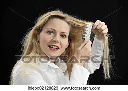 Young woman brushing her hair View Large Photo Image Stock Image - Young woman brushing her hair. Fotosearch