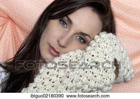 Stock Image - Young woman holding a shawl to her face, portrait. Fotosearch