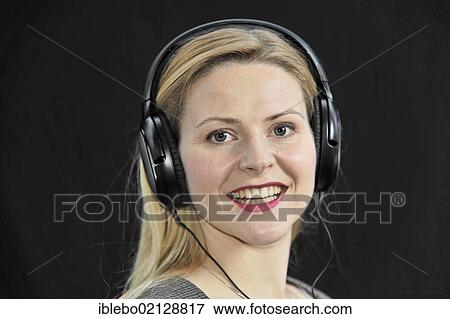 Young woman listening to music with headphones View Large Photo Image Stock Photo - Young woman listening to music with headphones. Fotosearch
