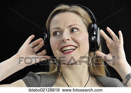 Young woman listening to music with headphones, enthusiastic View Large Photo Image Stock Photo - Young woman listening to music with headphones, enthusiastic. Fotosearch