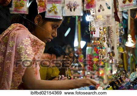 Young woman looking at bangles at street market, Kolkata, West Bengal, India, Asia View Large Photo Image Stock Photo - Young woman looking at bangles at street market, Kolkata, West Bengal, India, Asia. Fotosearch