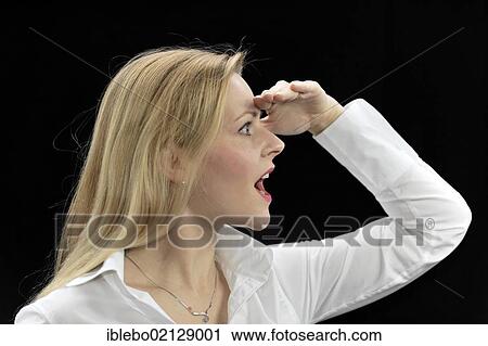 Stock Image - Young woman looking into the distance, surprised, pleased. Fotosearch