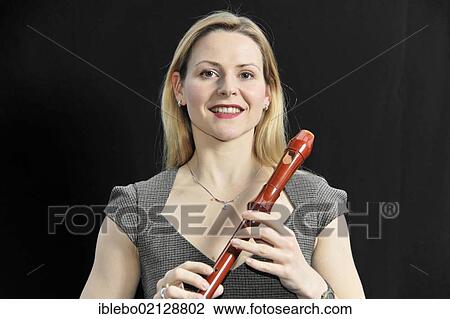 Stock Image - Young woman playing the alto recorder. Fotosearch