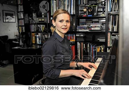 Stock Photograph - Young woman playing the piano. Fotosearch