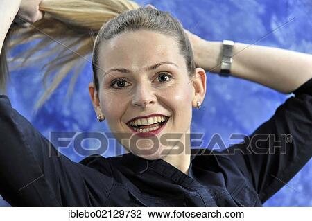 Stock Image - Young woman smiling, looking content. Fotosearch