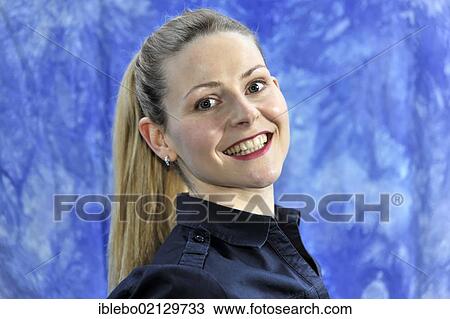 Stock Image - Young woman smiling, looking happy and content. Fotosearch