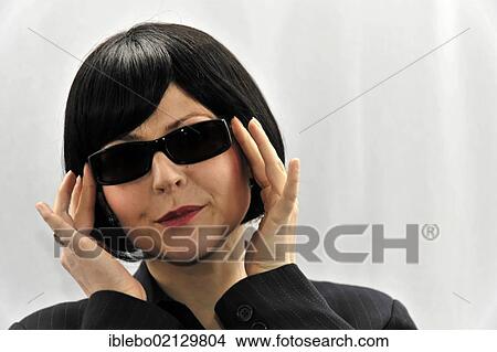 Picture - Young woman trying on sunglasses. Fotosearch