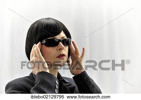 Stock Photography - Young woman trying on sunglasses. Fotosearch