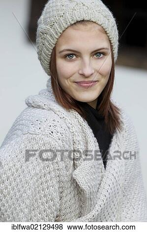 Stock Photo - Young woman wearing a cardigan and a woolen hat. Fotosearch