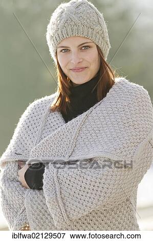 Stock Photo - Young woman wearing a cardigan and a woolen hat. Fotosearch