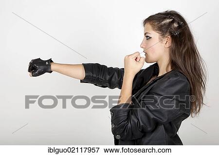 Young woman wearing a leather jacket with her fists held up in a challenge View Large Photo Image Stock Photo - Young woman wearing a leather jacket with her fists held up in a challenge. Fotosearch