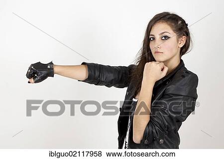 Young woman wearing a leather jacket with her fists held up in a challenge View Large Photo Image Stock Photo - Young woman wearing a leather jacket with her fists held up in a challenge. Fotosearch
