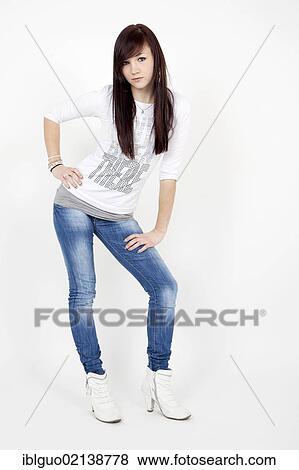 Stock Photo - Young woman wearing a white top and jeans, posing. Fotosearch