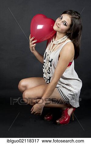Young woman with a heart balloon, a white top and high heels View Large Photo Image Stock Photo - Young woman with a heart balloon, a white top and high heels. Fotosearch