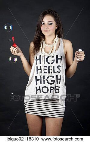 Young woman with soap bubbles and top with the words "High heels, high hopes" View Large Photo Image Stock Image - Young woman with soap bubbles and top with the words "High heels, high hopes". Fotosearch