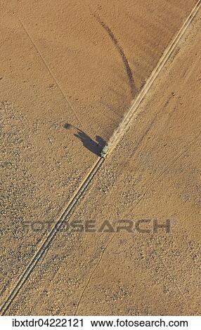 A vehicle of the balloon ground crew crosses a sandy plain at the edge of the Namib Desert, photographed from a hot-air balloon, NamibRand Nature Reserve, Namibia, Africa View Large Photo Image Stock Image - A vehicle of the balloon ground crew crosses a sandy plain at the edge of the Namib Desert, photographed from a hot-air balloon, NamibRand Nature Reserve, Namibia, Africa. Fotosearch