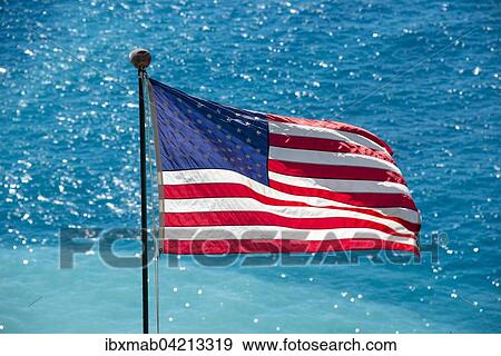 American flag blowing in the wind, blue sea behind View Large Photo Image Stock Photo - American flag blowing in the wind, blue sea behind. Fotosearch