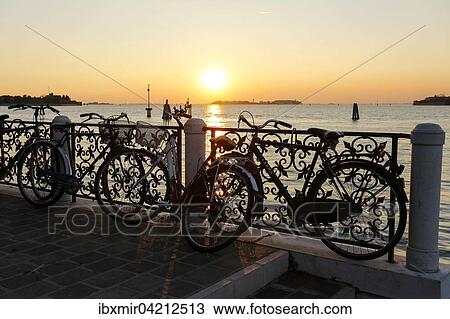 Bicycles leaning against a railing, evening mood atmosphere, view over the lagoon, Venice, Veneto, Italy, Europe View Large Photo Image Stock Image - Bicycles leaning against a railing, evening mood atmosphere, view over the lagoon, Venice, Veneto, Italy, Europe. Fotosearch