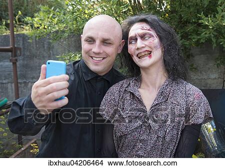 But first let me take a selfie, funny scene on the set of the zombie film Brain Freeze, actress Agnes Decker as a zombie View Large Photo Image Picture - But first let me take a selfie, funny scene on the set of the zombie film Brain Freeze, actress Agnes Decker as a zombie. Fotosearch